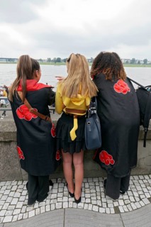 Three costumed woman looking at the Rhine, back view, cosplay at Japan Day Düsseldorf, North