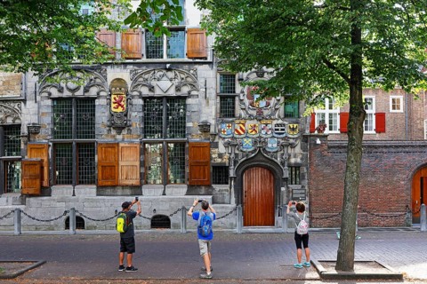 Historic city centre of Delft, tourists photograph Gemeenlandshuis van Delfland, town hall, oldest