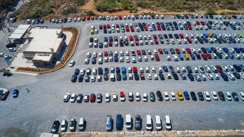 Overtourism, aerial view of a full car park with many different cars in sunny weather, Elafonissi,
