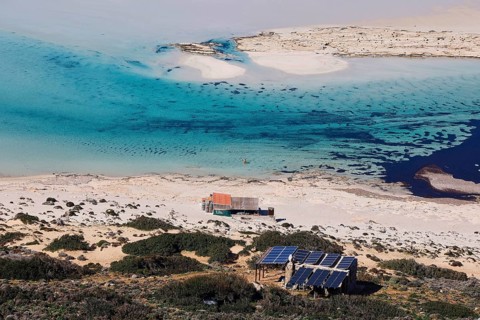 Caretaker building, Secluded beach with blue water and solar panels on the coast, Quiet and