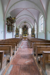 Parish church of St. Sebastian, interior with wooden benches and a central altar, high Gothic