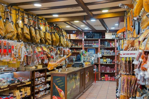 A rustic shop filled with hanging hams and other foods on the shelves, Plasencia, Cáceres, Caceres,