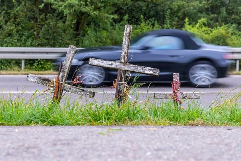 Cross on a country road, symbol of remembrance for three road accident victims. Laichigen,