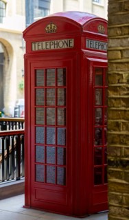Historic red telephone box in a canopied street scene, stylised and classically British, London,