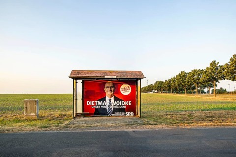 State election in Brandenburg. Bus shelter in an open field with an election poster of Prime