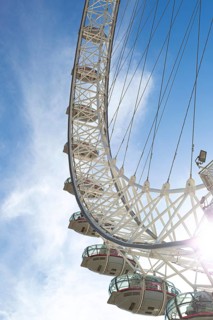 Detailed view of the London Eye Ferris wheel with metal structure and capsules under a blue sky,