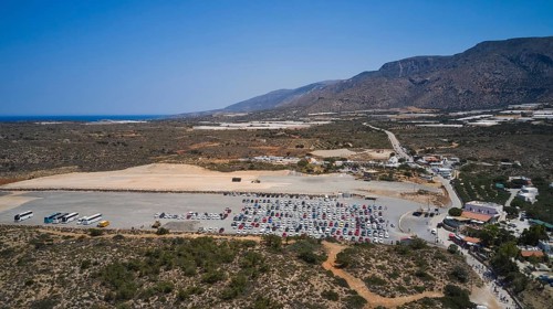 Overtourism, A large car park in the middle of an arid landscape, surrounded by mountains and a