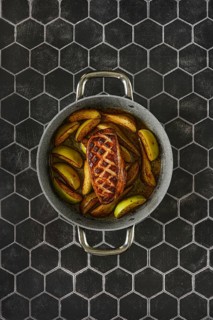 Savory perfectly seared duck breast with caramelized tender apples and pears in a rustic baking pan