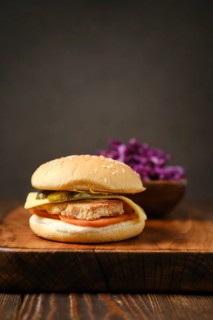 Close-up view of homemade hamburger with red cabbage salad on wooden board