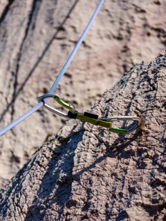 Climbing rope runs through a carabiner of an express sling, attached to a bolt, climbing area