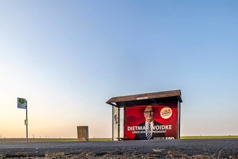 State election in Brandenburg. Bus shelter in an open field with an election poster of Prime