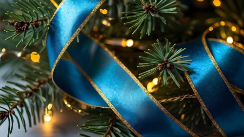 Christmas garland with gold and blue ribbons intertwined with pine needles and tiny twinkling