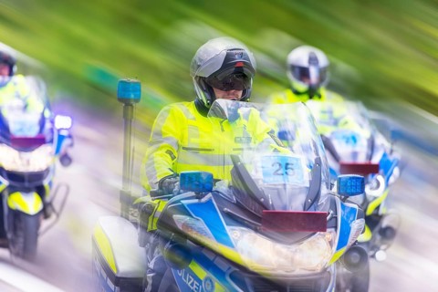 Police on motorbikes in bright safety clothing in motion with a blur effect on a street, Stuttgart,