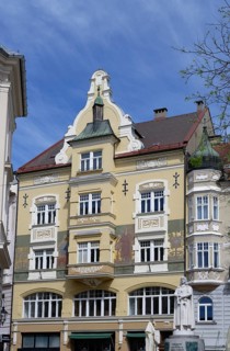 Historic building in the city centre with yellow façade and ornate cornices, Leonhaus,