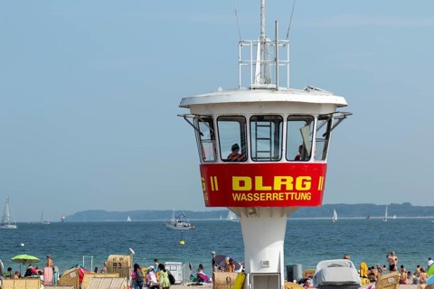 Summer weather, bathers, beach chairs and DLRG lifeguard tower on the beach, Travemünde beach,