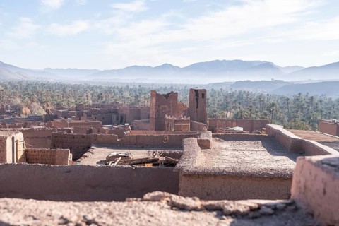 View of a village and an oasis of date palms from the rooftop of an ancient kasbha in Morocco