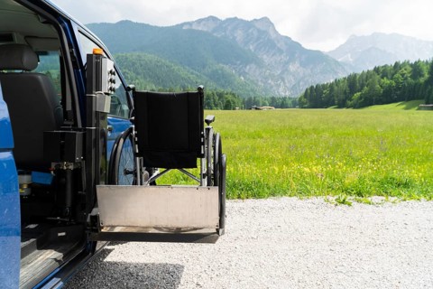 Photo of black electric lift specialized vehicle for people with disabilities. Empty wheelchair on