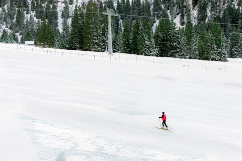Minimal style winter landscape with ski slope full of snow, surrounded by snowy fir trees, and a