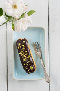 Eclair with chocolate ganache with pistachio topping