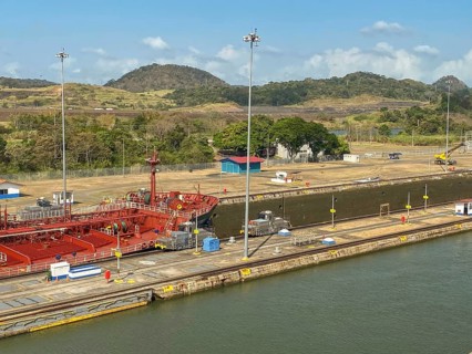 Ship in a lock in a canal, surrounded by industrial buildings, panama city, panamakanl, panama,