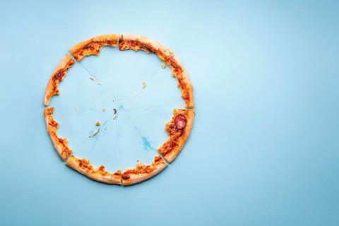 Pizza pepperoni leftovers top view on a blue background. Homemade pizza remainings and traces of