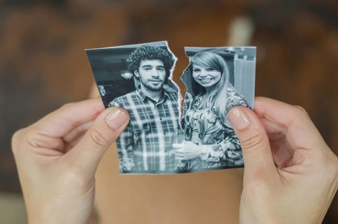 Great concept of divorce, betrayal, separation, woman hand ripping photo of the couple