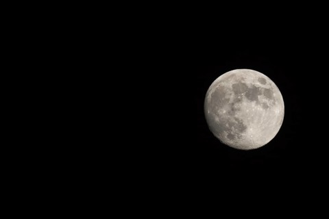 Waxing gibbous Moon, landscape orientated image with Moon isolated on black background with text or