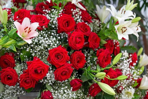 Bouquet of red roses and lilies with gypsophila
