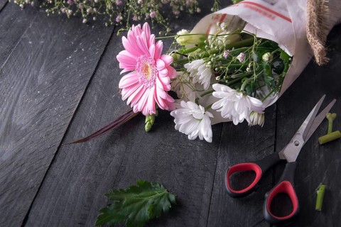Above view image about the activity of flower packaging, with a bouquet of chrysanthemum flowers