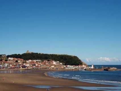 View of scarborough south bay with beach and town on a sunlit summer day with the harbour and