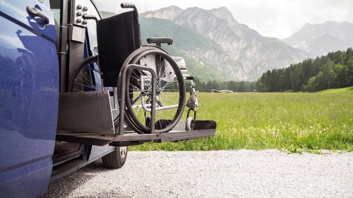 Photo of black electric lift specialized vehicle for people with disabilities. Empty wheelchair on