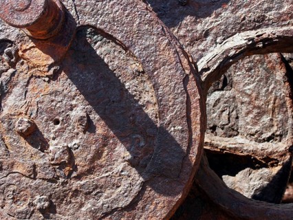 Corroded iron wheels covered in brown rust on old industrial machinery