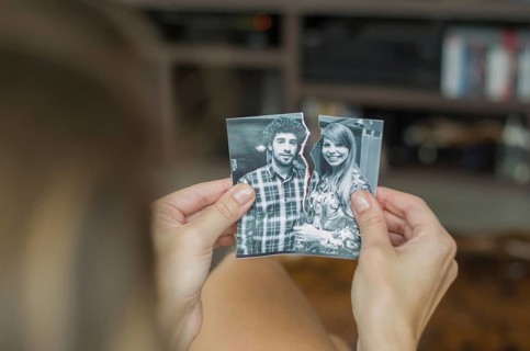 Great concept of divorce, betrayal, separation, woman hand ripping photo of the couple