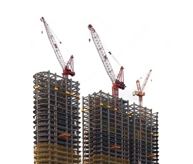 Half finished skyscraper steel frames with cranes on top
