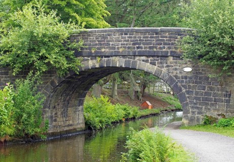 An old stone bridge crossing the rochdale canal at mytholmroyd west yorkshire with a waterside
