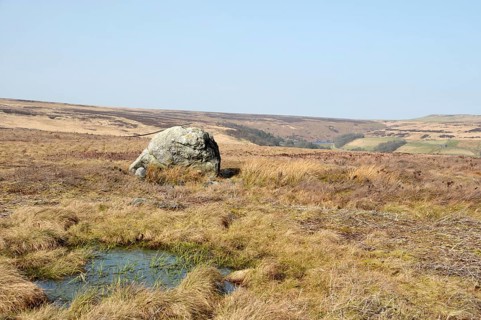 Pennine landscape with large old boulder or standing stone on midgley moor in west yorkshire