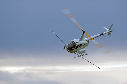 Helicopter spraying fertiliser on a crop in Westland, New Zealand, Oceania