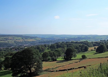 A scenic view of west yorkshire countryside with the town of sowerby visible at the bottom of the