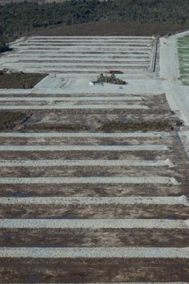 Digger excavating land to make humps and hollows for farmland, West Coast, South Island, New