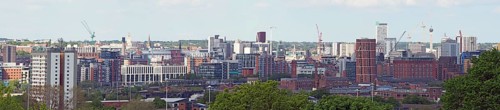 A wide panoramic view showing the whole of leeds city center with towers apartments roads and