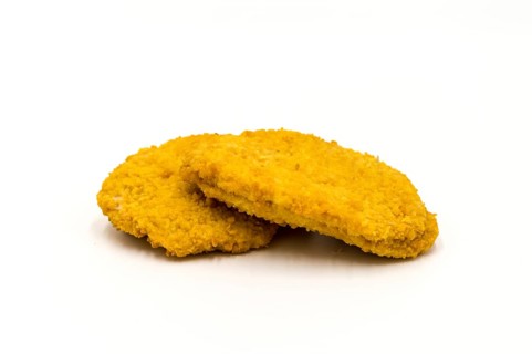 Slice of fresh breaded chicken on a white background