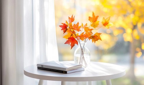 Contemporary white table with a couple of books and a vase of autumn foliage AI generated