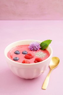 Raspberry smoothie bowl with blueberries, white chia seeds and raspberries in a bowl