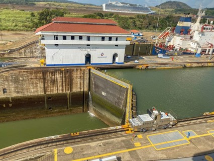 Industrial scene at a lock with a locomotive and a large white building. The sky is clear, panama
