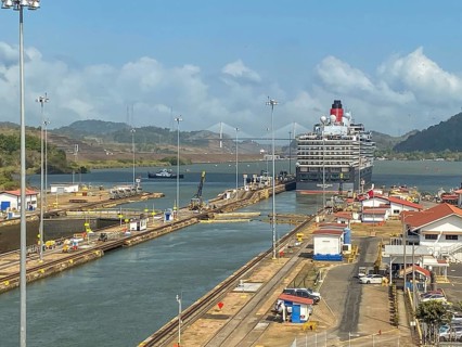 Cruise ship in a lock, surrounded by water and mountains under a blue sky, panama city, panamakanl,