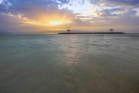 Beautiful seascape in the morning. Tropical sandy beach with breakwater and reflection of the sky