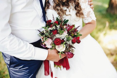 Bride and groom is holding wedding bouquet.