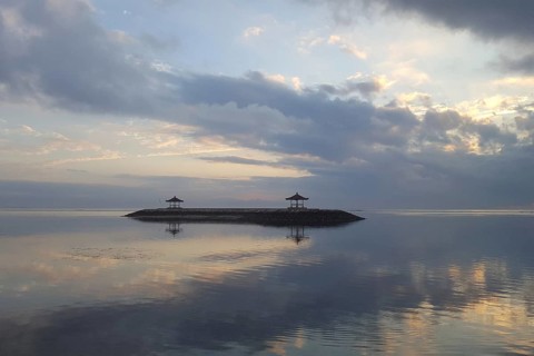 Beautiful seascape in the morning. Tropical sandy beach with breakwater and reflection of the sky