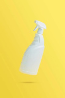 Levitation, flying blank toilet or window cleaner bottle with sprayer. Isolated on yellow
