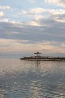 Beautiful seascape in the morning. Tropical sandy beach with breakwater and reflection of the sky